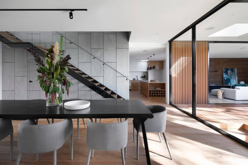 living-room-with-staircase-and-large-glass-windows-letting-light-in