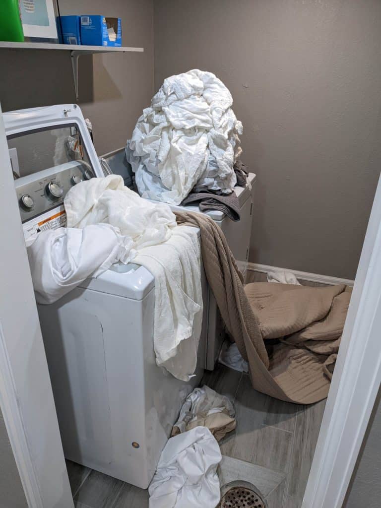 washer-and-dryer-in-laundry-room-with-linens-and-towels-on-top